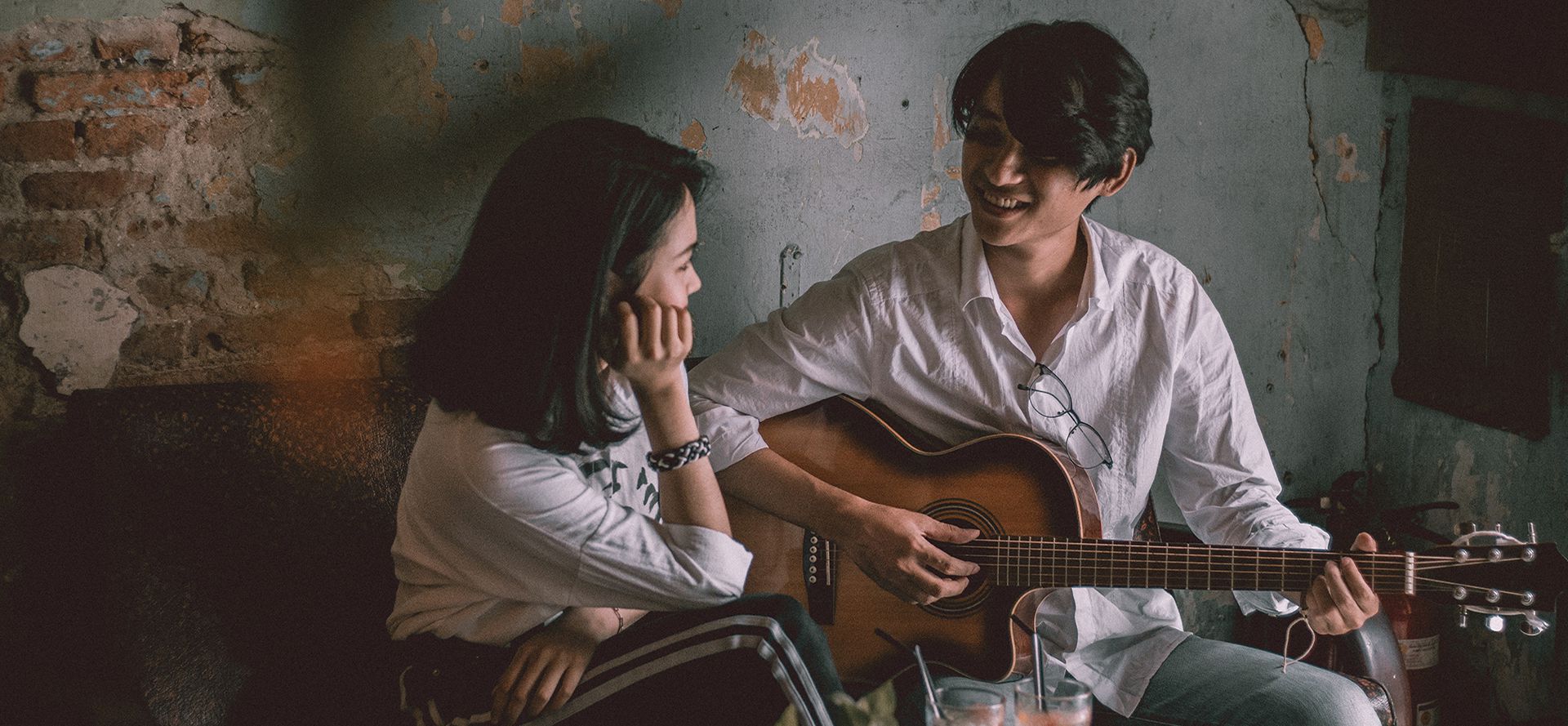 Taurus man playing guitar for woman.