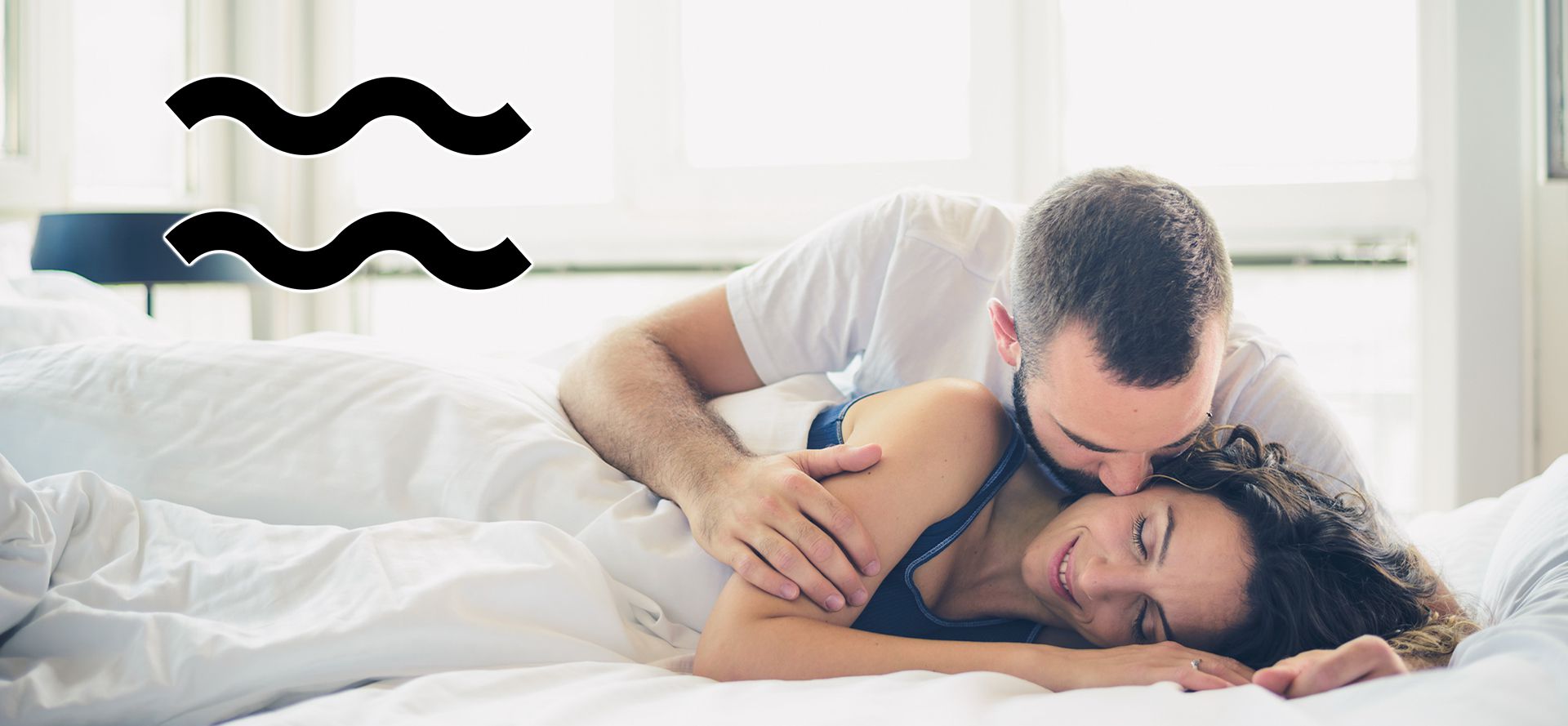 Aquarius man kissing a woman in Bed.