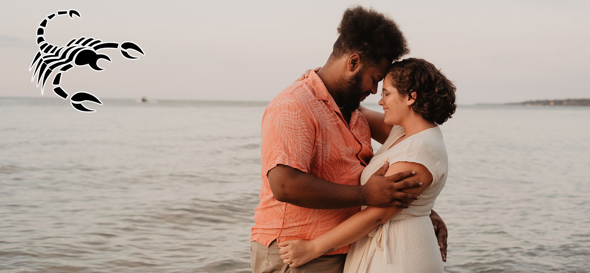 Scorpio man hugging a woman on the beach.