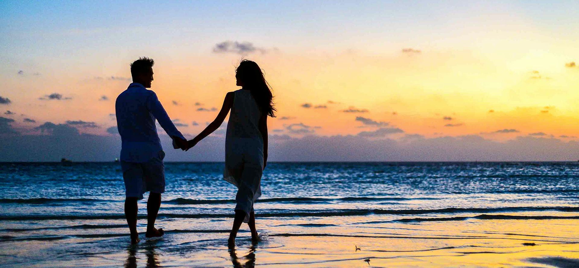 Pisces man walking with woman on the beach.