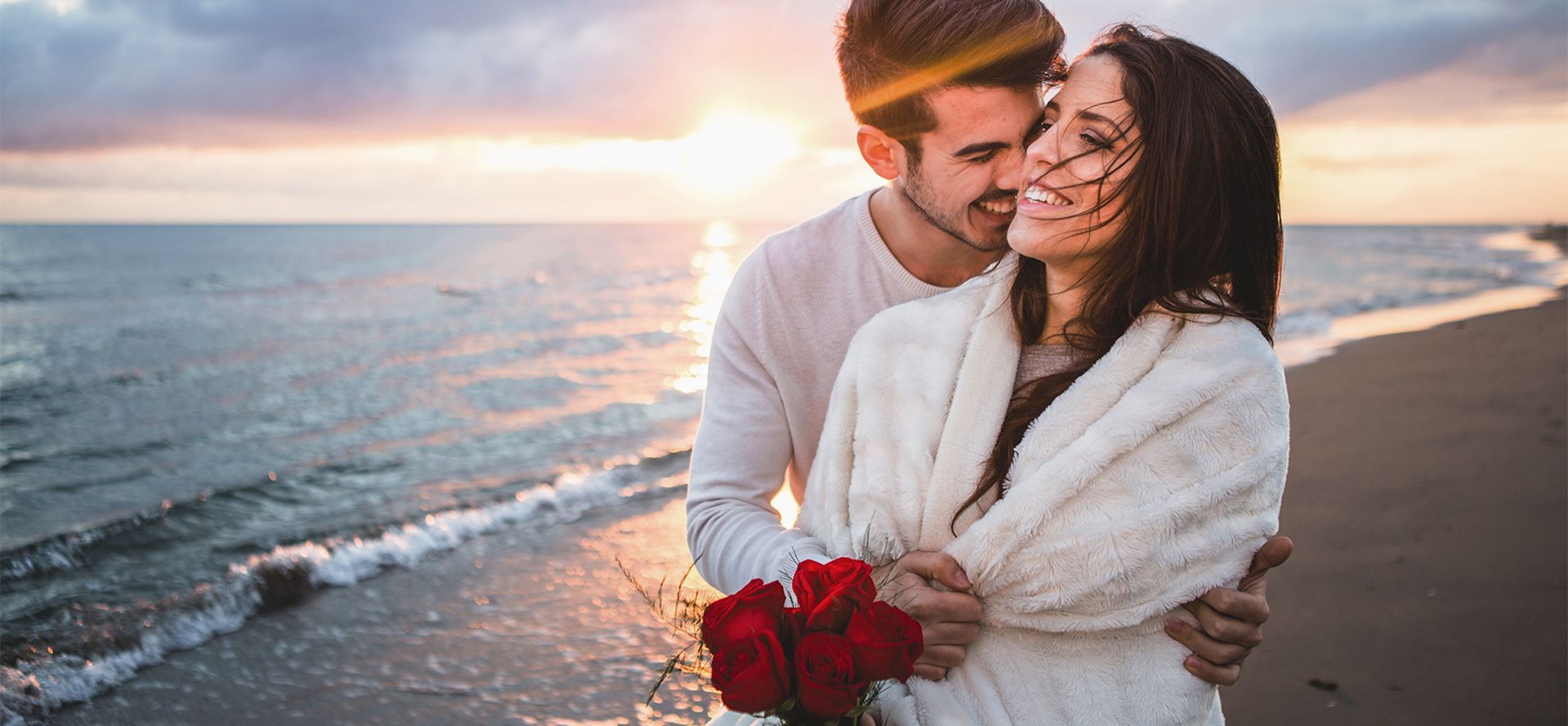 Scorpio man hugging woman on the beach.