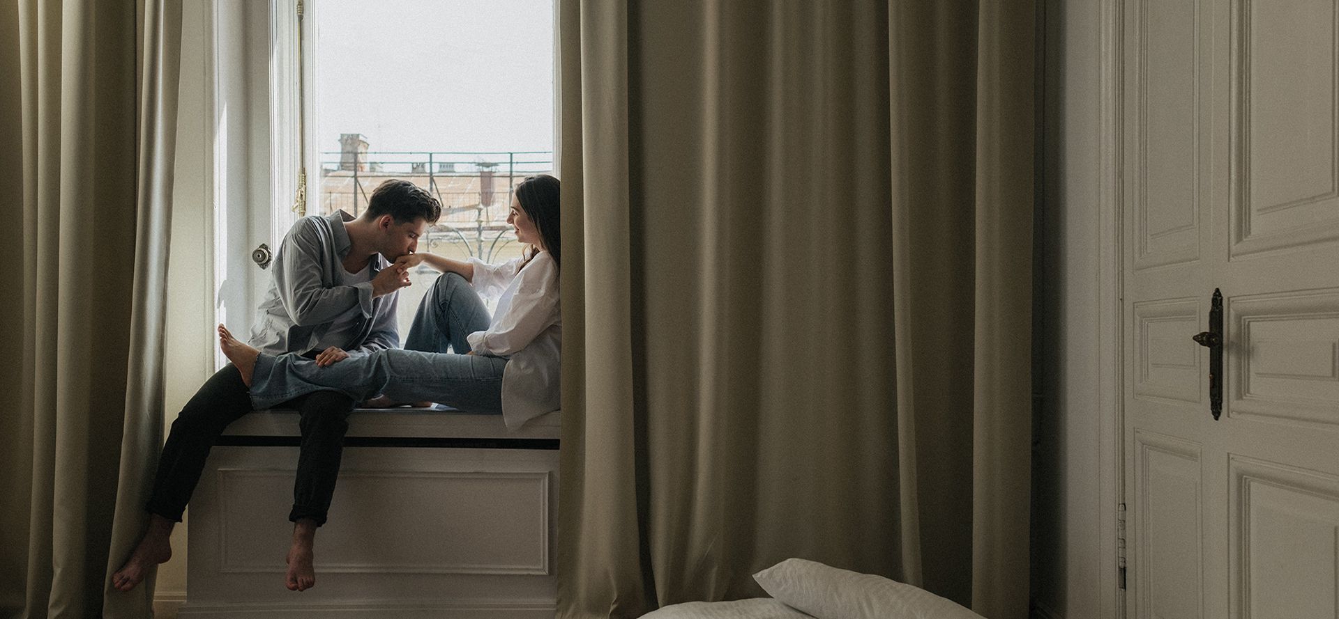 Woman and a leo man sitting on the windowsill.