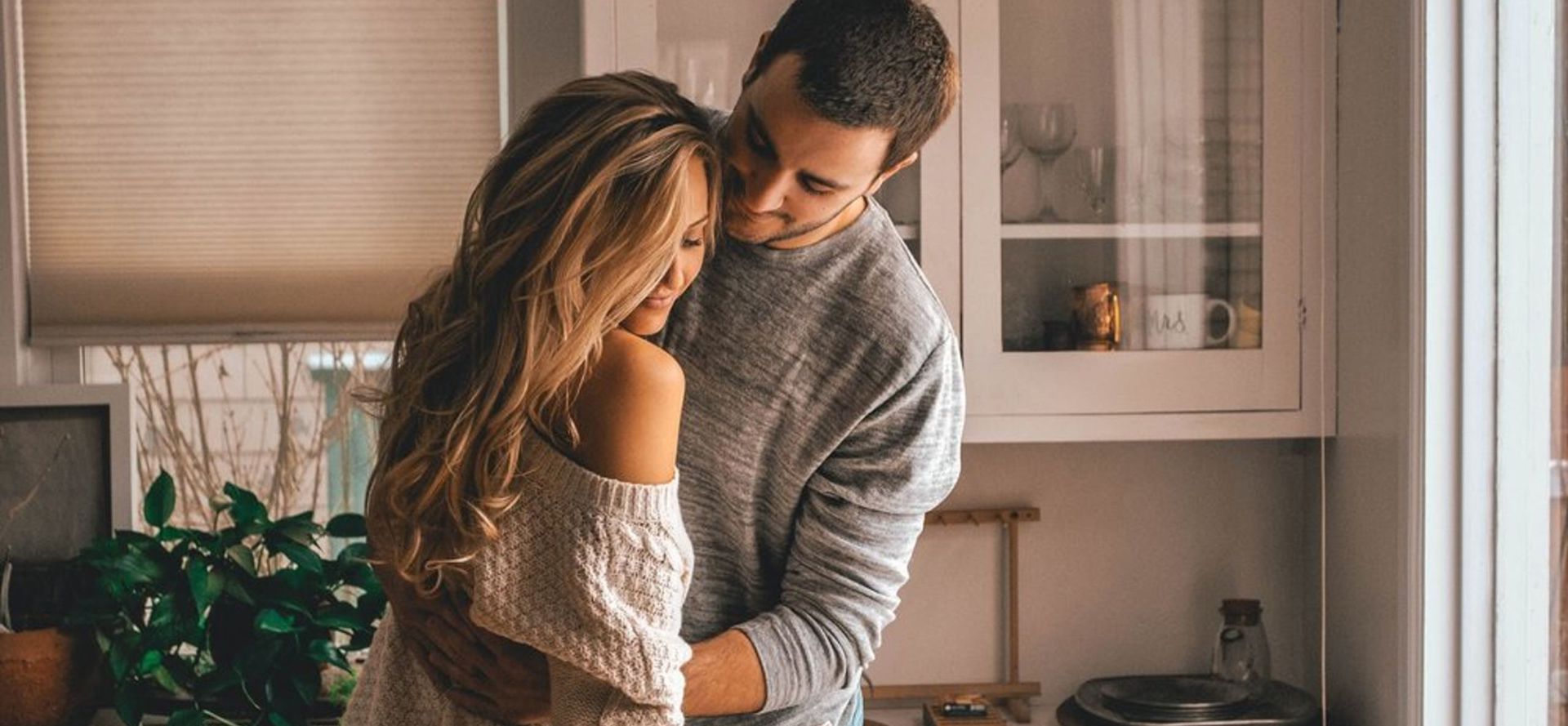 Virgo man hugging a woman in the kitchen.